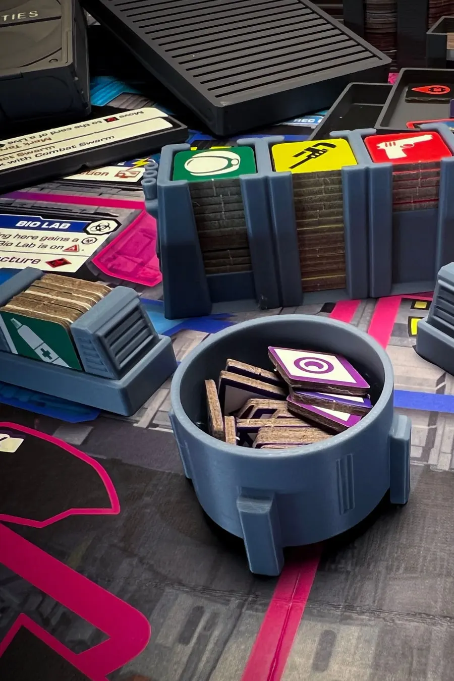 Printed Stationfall data-bank bins holding tokens, on the game board.